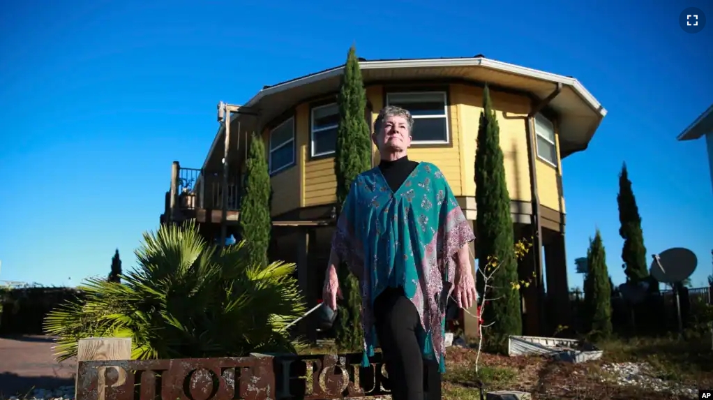 Bonny Paulson stands in front of her home in Mexico Beach, Fla. on Thursday, Oct. 19, 2023. The hurricane resistant house, designed by Deltec, was one of the few remaining structures left after Hurricane Michael hit the area in 2018. (AP Photo/Laura Bargfeld)