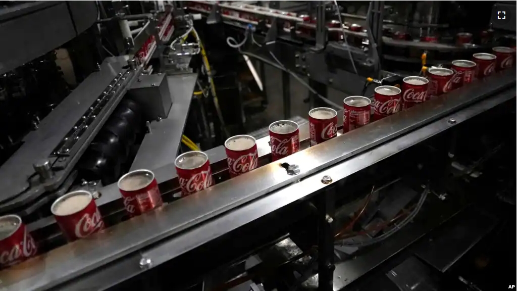 Coca-Cola cans move down a conveyer belt in the Swire Coca-Cola bottling plant Oct. 20, 2023, in Denver. (AP Photo/Brittany Peterson)