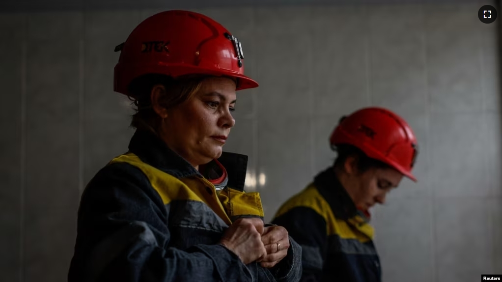 Nataliia, 43-years-old, and Krystyna, 22-years-old, dress in uniforms before going down to work their shift underground, amid Russia's attack on Ukraine, at a mine in Dnipropetrovsk region, Ukraine on November 17, 2023. (REUTERS/Alina Smutko)