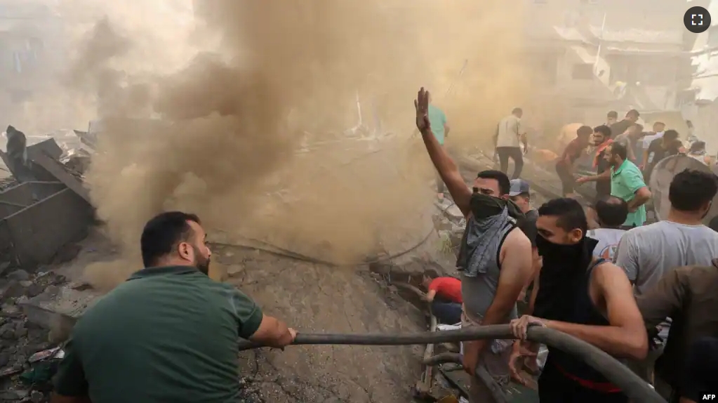 Palestinians go through the rubble of a building in Khan Yunis on November 6, 2023, amid the ongoing battles between Israel and the Palestinian group Hamas. (Photo by Mahmud HAMS / AFP)