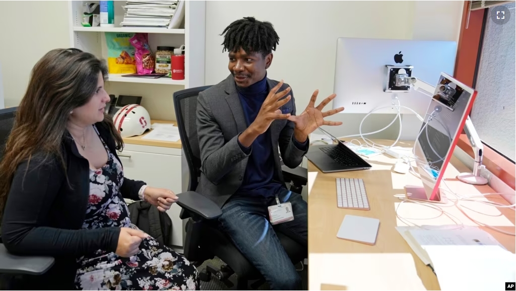 Post-doctoral researcher Tofunmi Omiye, right, gestures while talking in his office with assistant professor Roxana Daneshjou at the Stanford School of Medicine in Stanford, Calif., Tuesday, Oct. 17, 2023. (AP Photo/Eric Risberg)