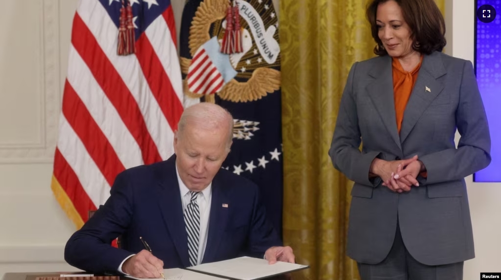 U.S. President Joe Biden signs an Executive Order about Artificial Intelligence as Vice President Kamala Harris looks on, in the East Room at the White House in Washington, U.S., October 30, 2023. (REUTERS/Leah Millis)