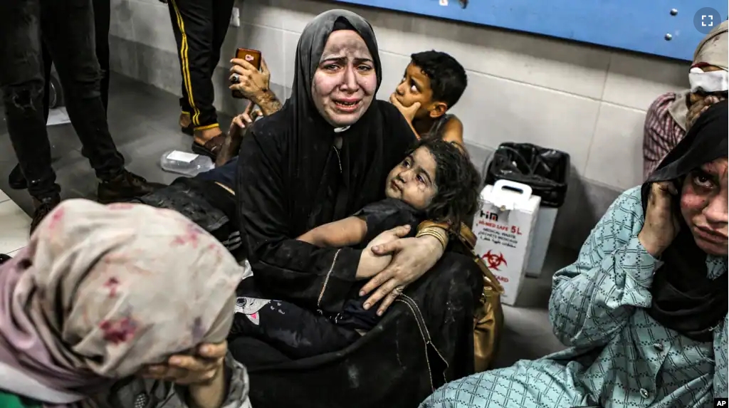 Wounded Palestinians sit in al-Shifa Hospital in Gaza City, central Gaza Strip, after arriving from al-Ahli Hospital following an explosion there, Oct. 17, 2023. (AP Photo/Abed Khaled, File)