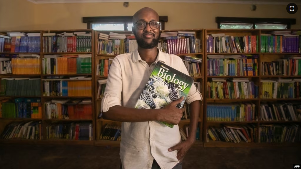 This handout picture taken on Nov. 8, 2023, shows Abdullahi Mire, winner of the U.N. refugee agency's prestigious Nansen Award posing for a picture in one of the libraries he established in Kenya's Dadaab refugee camp. (AFP Photo/UNHCR)