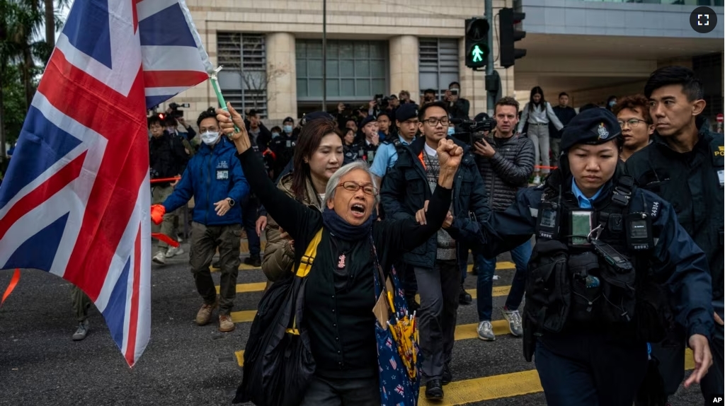 Activist Alexandra Wong, also known as Grandma Wong, holds a flag of Britain outside West Kowloon Magistrates' Courts, where activist publisher Jimmy Lai's trial is scheduled to open, in Hong Kong, Monday, Dec. 18, 2023. (AP Photo/Vernon Yuen)