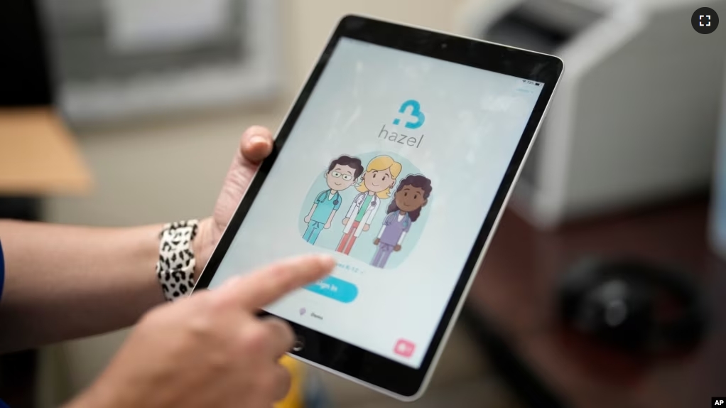 An employee of Hazel Health displays the opening page of the company's app, Tuesday, Oct. 10, 2023 (AP Photo/Rebecca Blackwell)