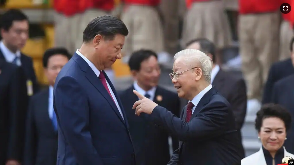 China's President Xi Jinping, center left, and Vietnam's Communist Party General Secretary Nguyen Phu Trong, center right, attend a welcome ceremony at the Presidential Palace in Hanoi, Vietnam, Tuesday Dec. 12, 2023. (Nhac Nguyen/Pool via AP)