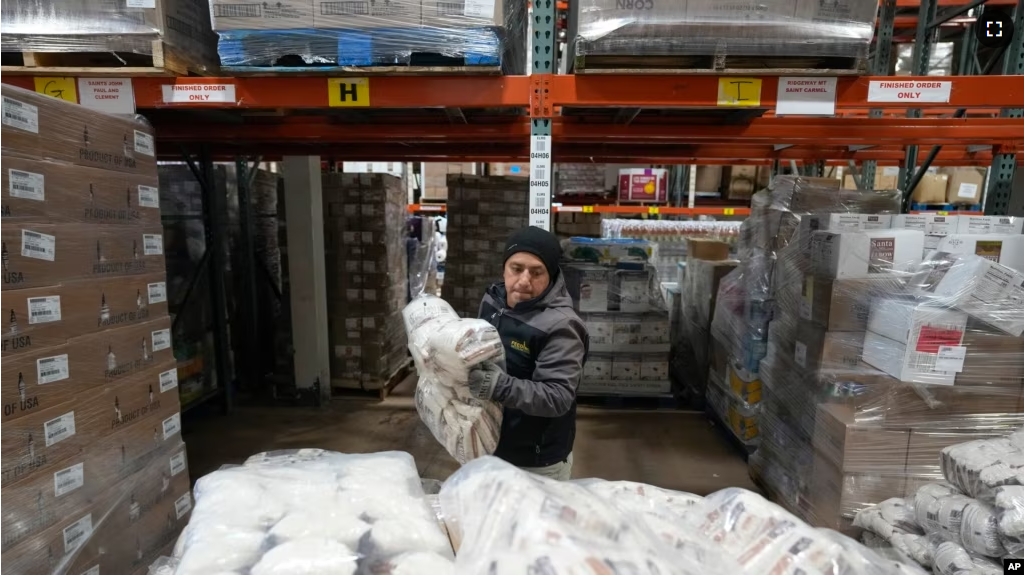 Driver Carlos Quezada loads rice on a pallet for distribution at Feeding Westchester in Elmsford, N.Y., Wednesday, Nov. 15, 2023. (AP Photo/Seth Wenig)