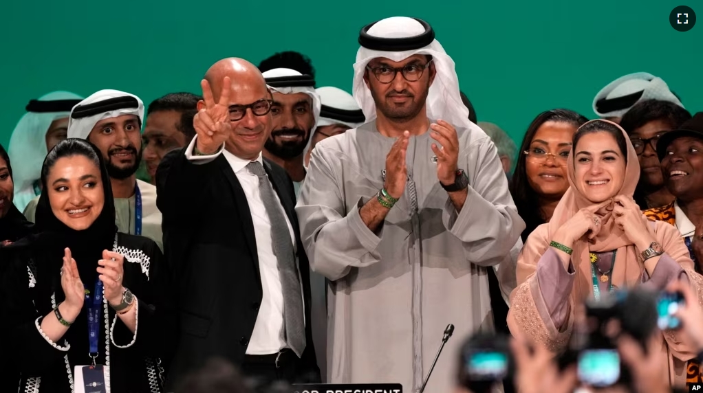 U.N. Climate Chief Simon Stiell, from left, COP28 President Sultan al-Jaber and Hana Al-Hashimi, chief COP28 negotiator for the United Arab Emirates, pose at the end of the COP28 U.N. Climate Summit, on Dec. 13, 2023, in Dubai, United Arab Emirates. (AP Photo/Kamran Jebreili)