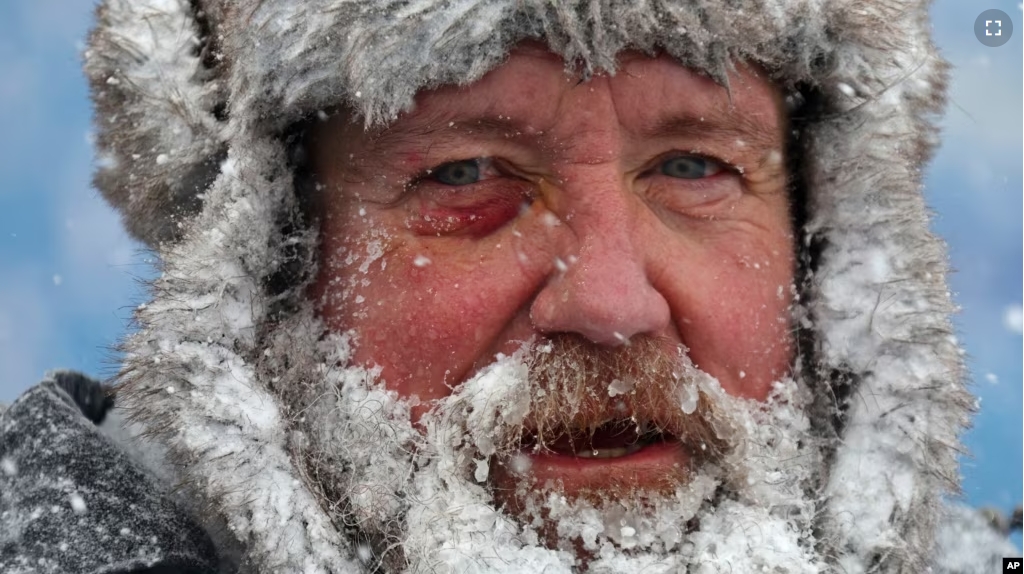 FILE - A worker pauses while removing snow from Highmark Stadium in Orchard Park, N.Y., Jan. 14, 2024. While the U.S. is shivering through bone-chilling cold, most of the rest of world is feeling unusually warm weather. (AP Photo/ Jeffrey T. Barnes, File)