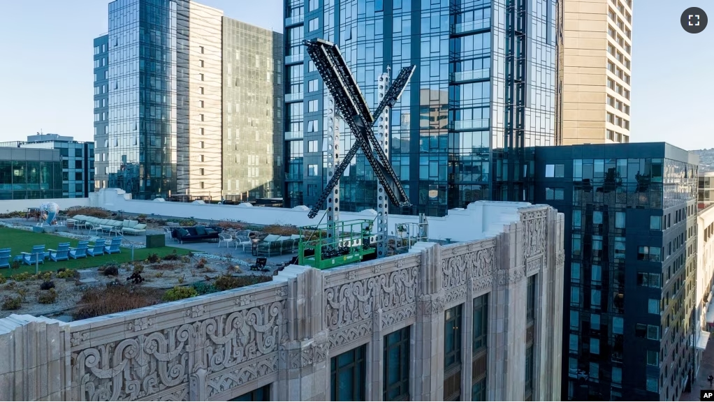 FILE - An "X" sign rests atop the company headquarters in downtown San Francisco, on July 28, 2023. Elon Musk's social media company, formerly known as Twitter, has filed a lawsuit against liberal advocacy group Media Matters. (AP Photo/Noah Berger, File)