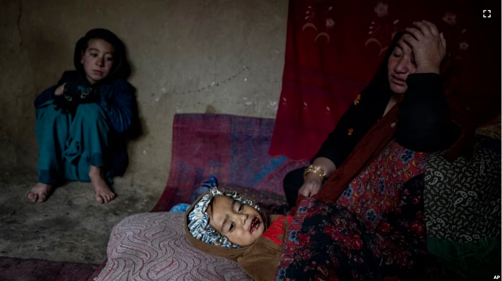 An internally displaced woman takes care of her sick child in a camp on the outskirts of Kabul, Afghanistan, Thursday, Feb. 9, 2023. She has no money to treat her sick child. (AP Photo/Ebrahim Noroozi)