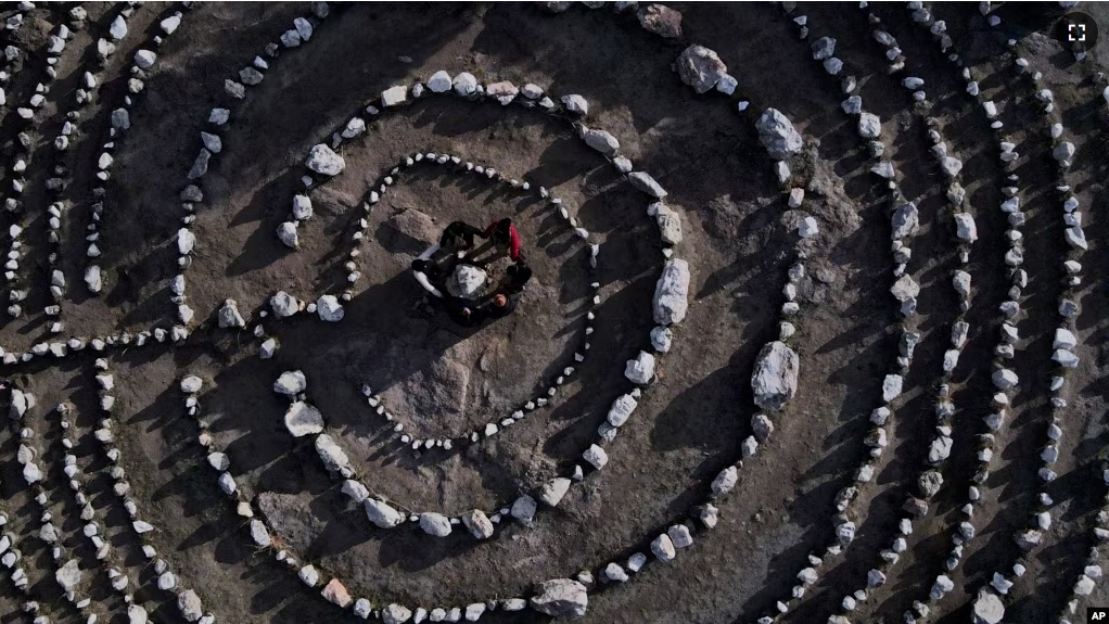 FILE - Brazilian tourists hold hands standing in a circle in the Pueblo Encanto park in Capilla del Monte, Argentina, July 19, 2023. Known as the "nones," they describe themselves as atheists or "nothing in particular." (AP Photo/Natacha Pisarenko, File)