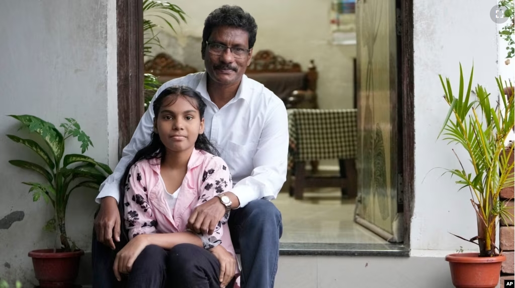 Gautam Dongre, of the National Alliance of Sickle Cell Organizations, sits for a portrait with his daughter, Sumedha, 13, at their residence in Nagpur, India, Wednesday, Dec. 6, 2023. (AP Photo/Ajit Solanki)