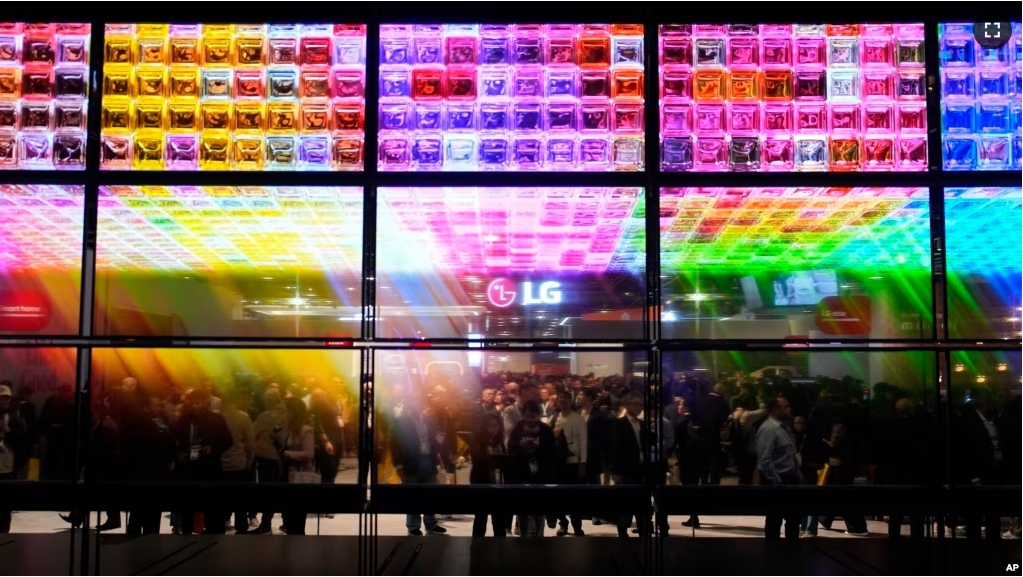 People look at an exhibit of LG Signature OLED T 4K transparent wireless TV's at the LG booth during the CES tech show Tuesday, Jan. 9, 2024, in Las Vegas. (AP Photo/John Locher)