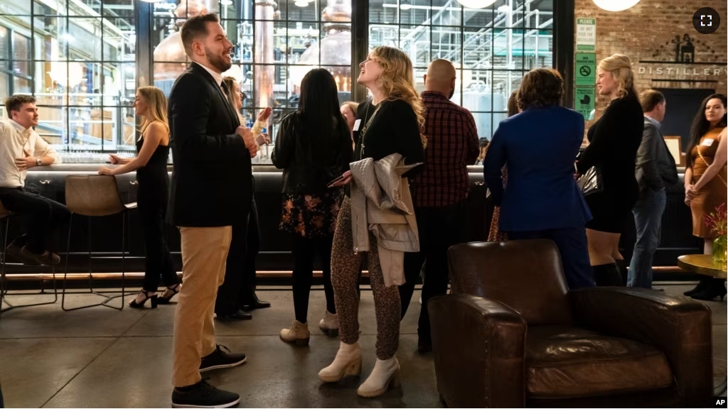 People mingle at a Philadelphia Distilling Daters Mixer Hosted by Date Him Philly, in Philadelphia, Tuesday, Nov. 14, 2023. (AP Photo/Matt Rourke)