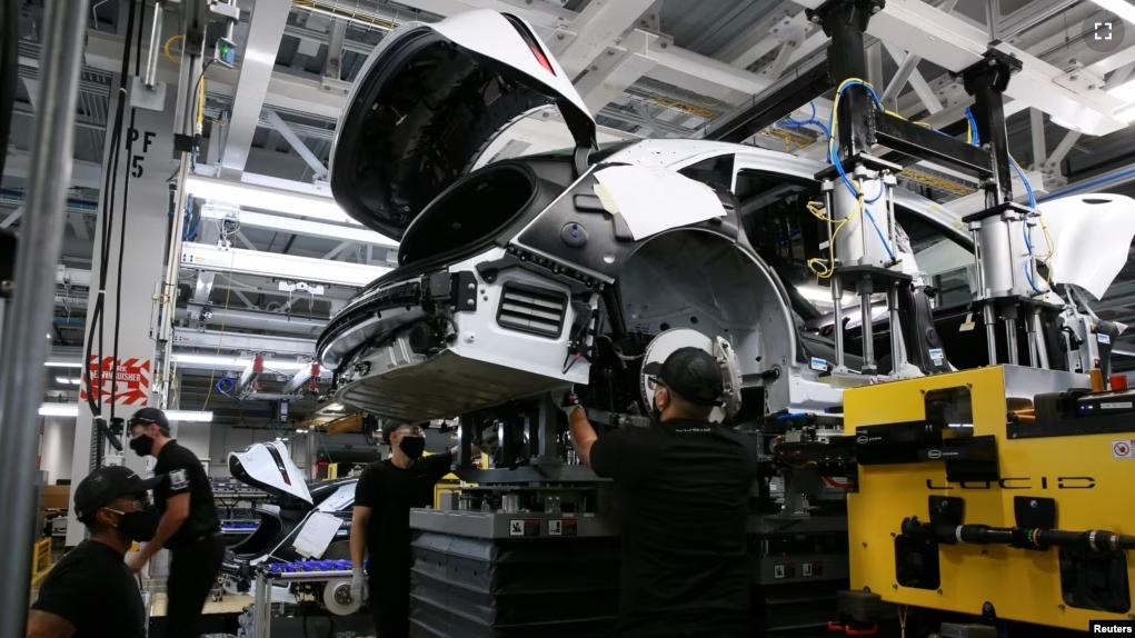 FILE - Workers marry the body structure with the battery pack and the front and rear sub frames as they assemble electric vehicles at the Lucid Motors plant in Casa Grande, Arizona, U.S. September 28, 2021. (REUTERS/Caitlin O'Hara/File Photo)