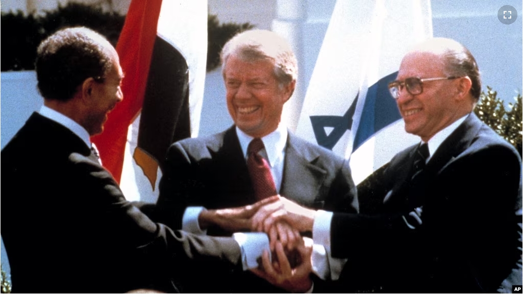 FILE - In this March 26, 1979 file photo, Egyptian President Anwar Sadat, left, U.S. President Jimmy Carter, center, and Israeli Prime Minister Menachem Begin clasp hands as they completed signing of the peace treaty. (AP Photo/Bob Daugherty, File)