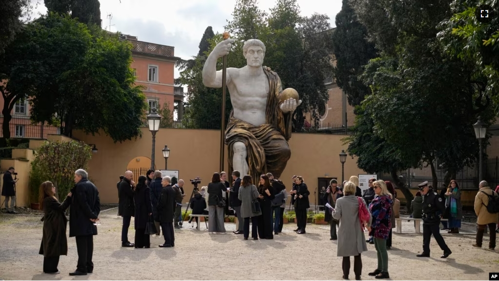 Visitors admire a massive, 13-meter replica of the statue of Roman Emperor Constantine that was built using 3D technology from scans of the nine giant original marble body parts that remain. Tuesday, Feb. 6, 2024.(AP Photo/Andrew Medichini)