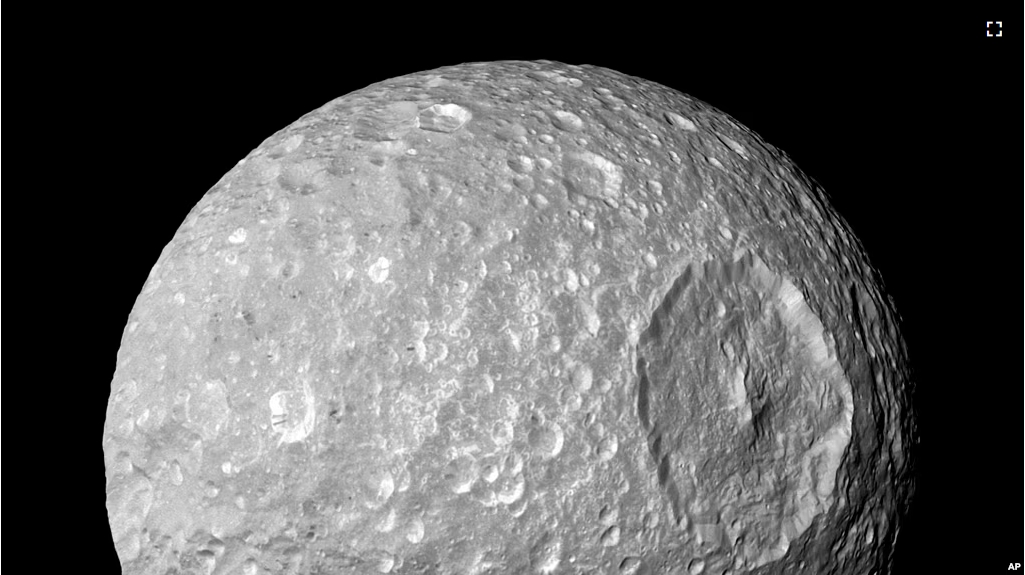 This Feb. 13, 2010 image provided by NASA shows Saturn's moon Mimas and it's large Herschel Crater, captured by the Cassini spacecraft. (NASA/JPL-Caltech/Space Science Institute via AP)