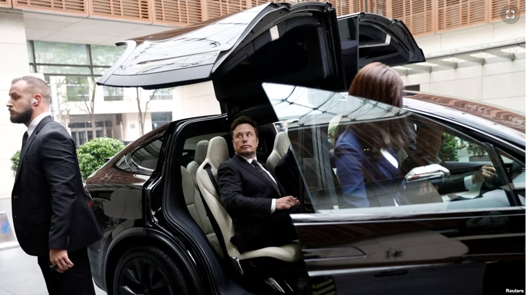 FILE - Tesla Chief Executive Officer Elon Musk gets in a Tesla car as he leaves a hotel in Beijing, China May 31, 2023. (REUTERS/Tingshu Wang)