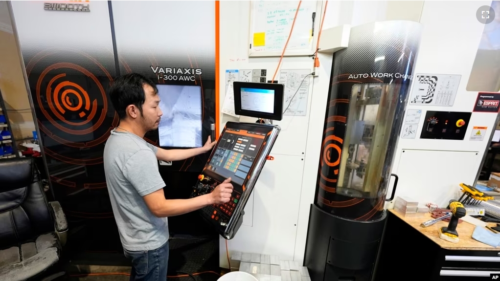 FILE - A worker at Reata Engineering and Machine Works programs a Mazak Variaxis machine used to make semiconductor pieces, Thursday, Feb. 15, 2024, in Englewood, Colo. (AP Photo/David Zalubowski)