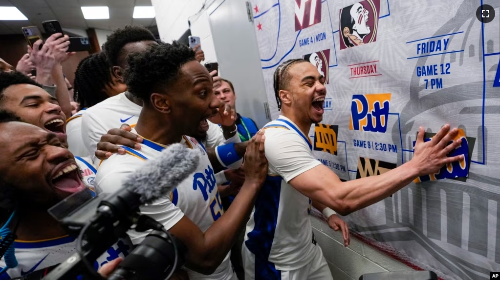 Pittsburgh guard Ishmael Leggett, right, places a decal on the bracket after an NCAA college basketball game on March 14, 2024. (AP Photo/Susan Walsh, File)
