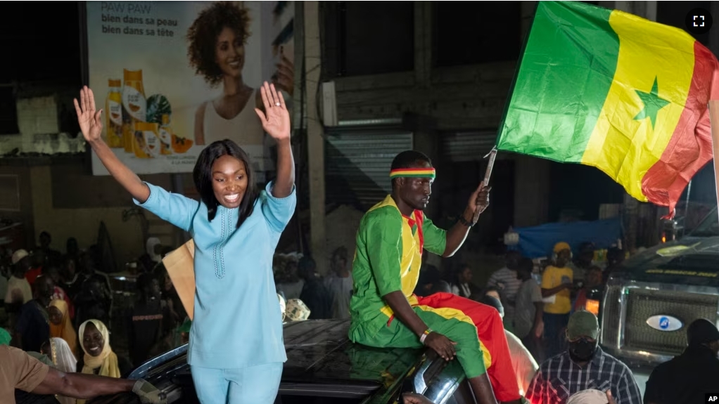 Presidential candidate Anta Babacar Ngom greets supporters during her electoral campaign caravan in Dakar, Senegal, Monday, March 11, 2024. (AP Photo/Sylvain Cherkaoui)
