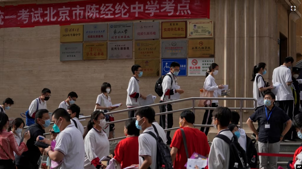 FILE - Students line up to enter a school for the first day of China's national college entrance examinations, known as the gaokao, in Beijing, Tuesday, June 7, 2022. (AP Photo/Andy Wong, File )