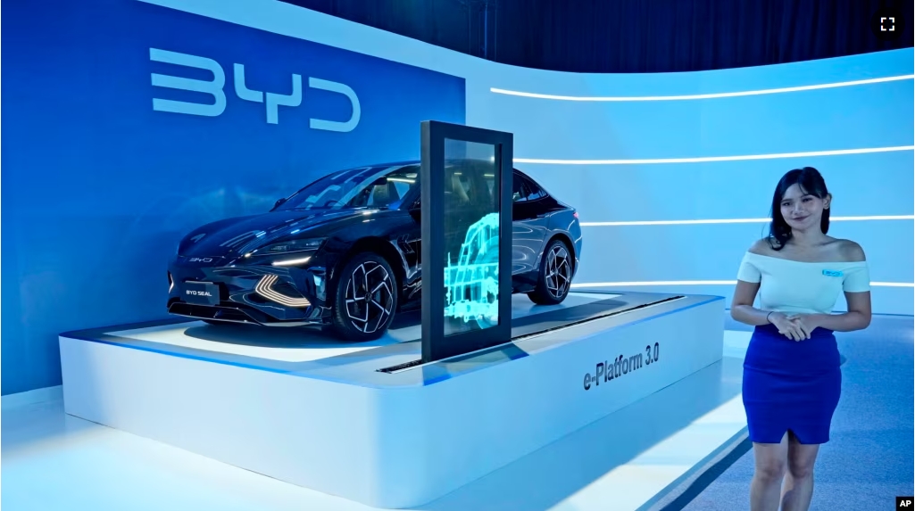 FILE - A model stands near a BYD Seal electric car displayed during its launch event in Jakarta, Indonesia, on Jan. 18, 2024. (AP Photo/Achmad Ibrahim, File)