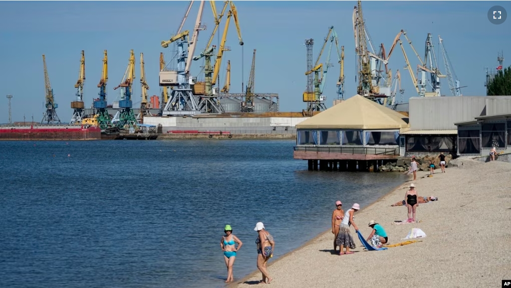 FILE - Local residents relax on a city beach in Berdiansk, a region under Russian military control, southeastern Ukraine, June 14, 2022. (AP Photo)