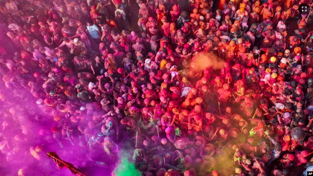 FILE - People celebrate with bright colors for Lathmar Holi at Nandagram temple in Nandgoan village, 115 kilometers (70 miles) south of New Delhi, India, March 19, 2024. (AP Photo/Rajesh Kumar Singh)