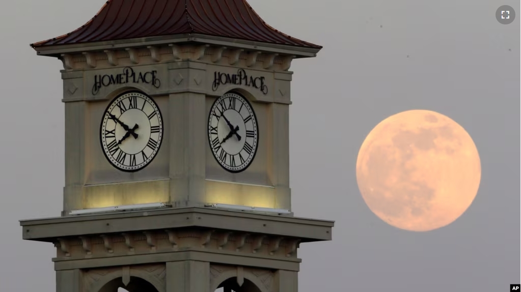 FILE - The moon rises behind the Home Place clock tower in Prattville, Ala., Saturday, June 22, 2013. (AP Photo/Dave Martin, File)