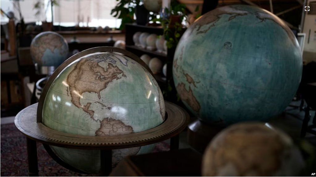 Various size of globes are displayed at a studio in London, Tuesday, Feb. 27, 2024. Globes in the age of Google Earth capture the imagination and serve as snapshots of how the owners see the world and their place in it. (AP Photo/Kin Cheung)