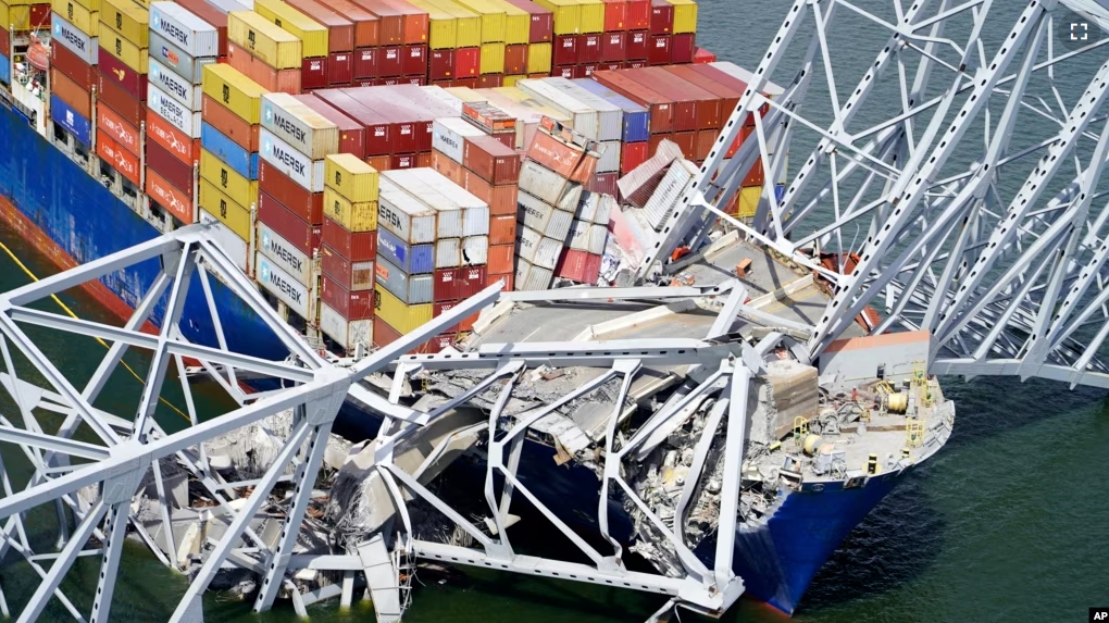 In this aerial image released by the Maryland National Guard, the cargo ship Dali is stuck under part of the structure of the Francis Scott Key Bridge after the ship hit the bridge, Tuesday, March 26, 2024, in Baltimore. (Maryland National Guard via AP)