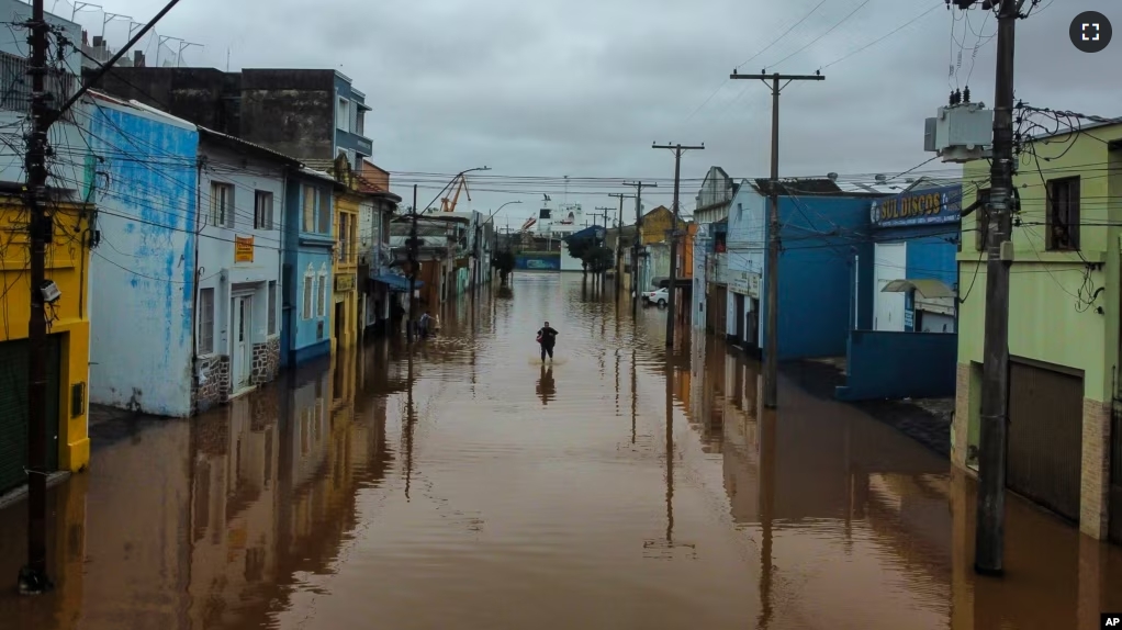 A man wades through an area flooded by heavy rains, in Porto Alegre, Rio Grande do Sul state, Brazil, May 3, 2024.(AP Photo/Carlos Macedo, File)