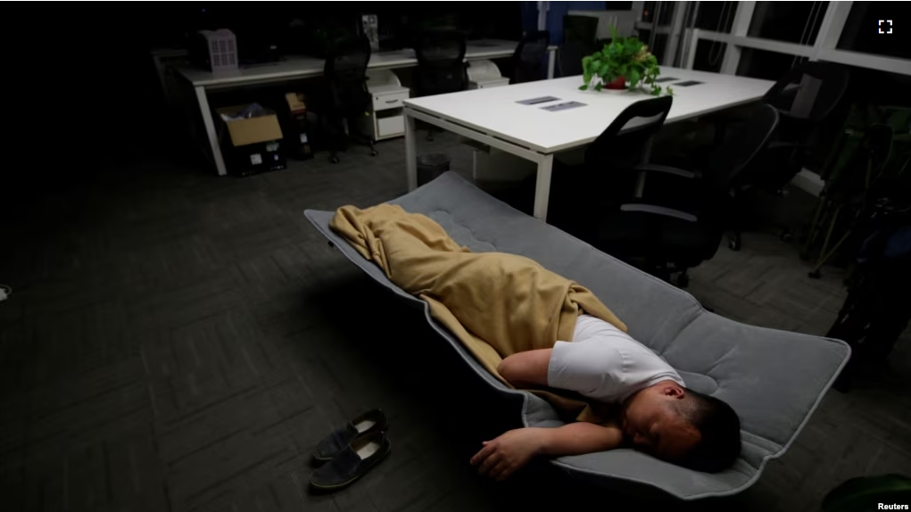 FILE - A worker sleeps in the office after finishing work early morning, in Beijing, China, April 27, 2016. (REUTERS/Jason Lee)