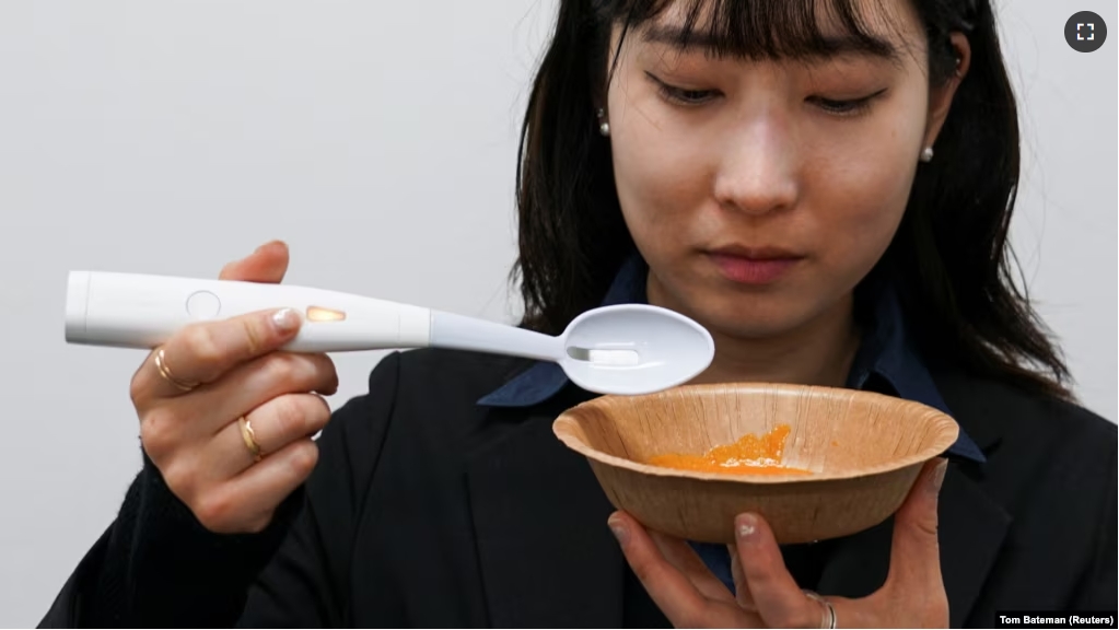 An employee of Kirin Holdings demonstrates an electric spoon in Tokyo, May 20, 2024. (REUTERS/Tom Bateman)