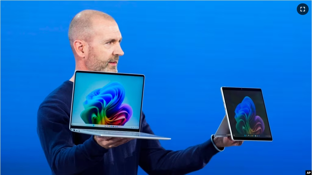 Brett Ostrum, Microsoft corporate vice president of Surface, holds up the new Surface Laptop and Surface Pro with built-in AI at an event of the company's AI assistant, Copilot, Monday, May 20, 2024, in Redmond, Wash. (AP Photo/Lindsey Wasson)