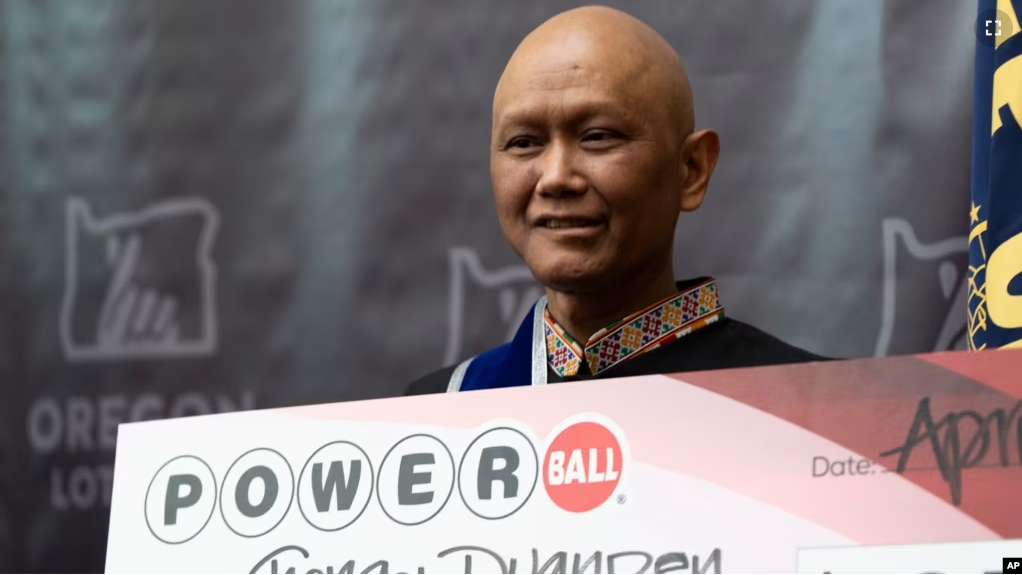 Cheng "Charlie" Saephan holds display check during a news conference where it was revealed that he was one of the winners of the $1.3 billion Powerball jackpot at the Oregon Lottery headquarters, April 29, 2024, in Salem, Ore. (AP Photo/Jenny Kane)