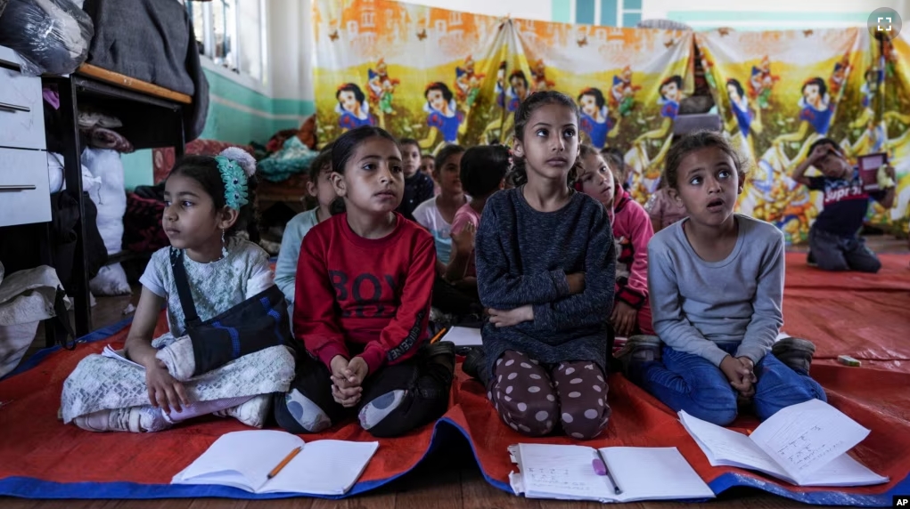 Children attend an activity at a makeshift class in Deir al Balah, on Sunday, April 21, 2024. (AP Photo/Abdel Kareen Hana)