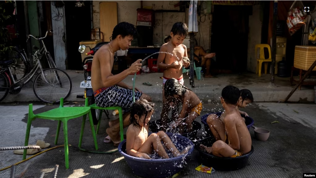 Children sit in buckets and basins during a hot day in Manila, Philippines, April 29, 2024. (REUTERS/Eloisa Lopez)