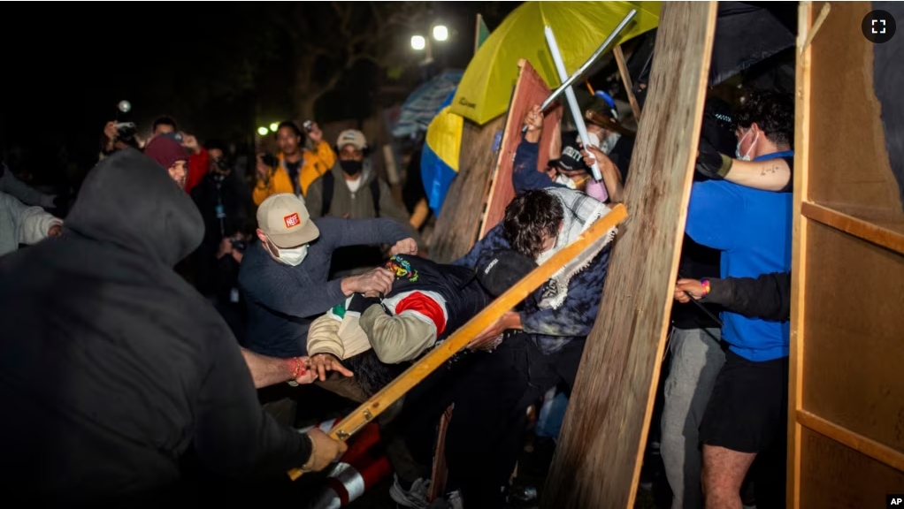 Demonstrators clash at a pro-Palestinian encampment at UCLA early Wednesday, May 1, 2024, in Los Angeles. (AP Photo/Ethan Swope)