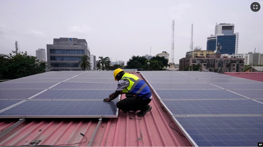 Oladapo Adekunle, an engineer with Rensource Energy, installs solar panels on a roof of a house in Lagos, Nigeria, Thursday, March 21, 2024. (AP Photo/Sunday Alamba)