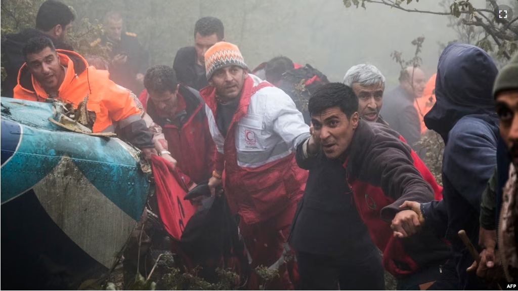 Rescuers recover bodies at the crash site of a helicopter transporting Iran's President, his Foreign Minister, and others in a fog-covered mountainous area of Varzaghan in northwestern Iran on May 20, 2024. (Photo by Azin HAGHIGHI / MOJ News Agency / AFP)