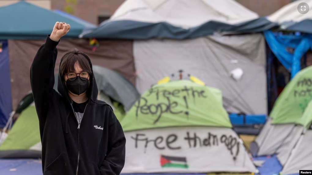 FILE - Student protest organizer, Steph W. raises her right fist as she poses for a portrait at an encampment in support of Palestinians in Gaza at the Auraria Campus in Denver, Colorado, U.S., May 10, 2024. (REUTERS/Kevin Mohatt)