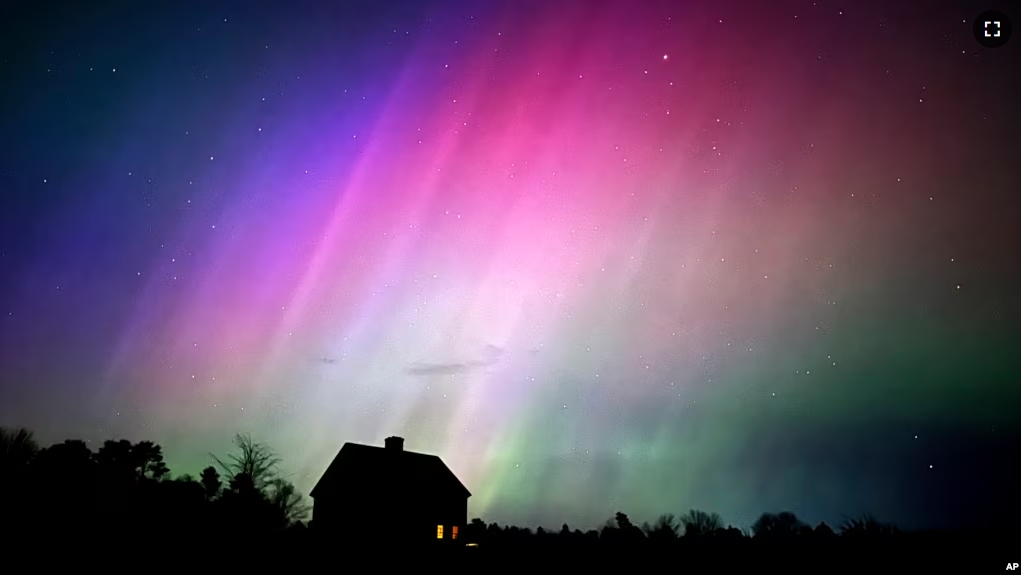 The northern lights flare in the sky over a farmhouse, late Friday, May 10, 2024, in Brunswick, Maine. (AP Photo/Robert F. Bukaty)