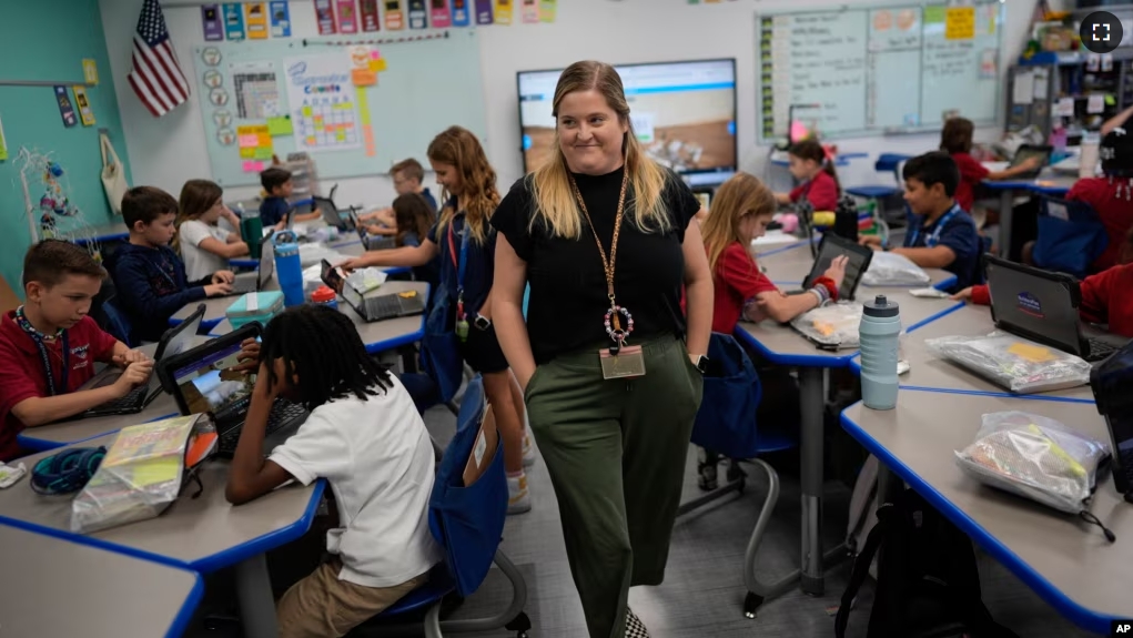 Third grade teacher Megan Foster walks through her classroom as students take a break from a reading lesson, Tuesday, April 16, 2024. (AP Photo/Rebecca Blackwell)