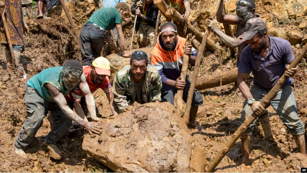 Villagers move a rock as part of search efforts following a devastating landslide, in Yambali village, in the Highlands of Papua New Guinea, May 27, 2024. (Juho Valta/UNDP Papua New Guinea via AP)