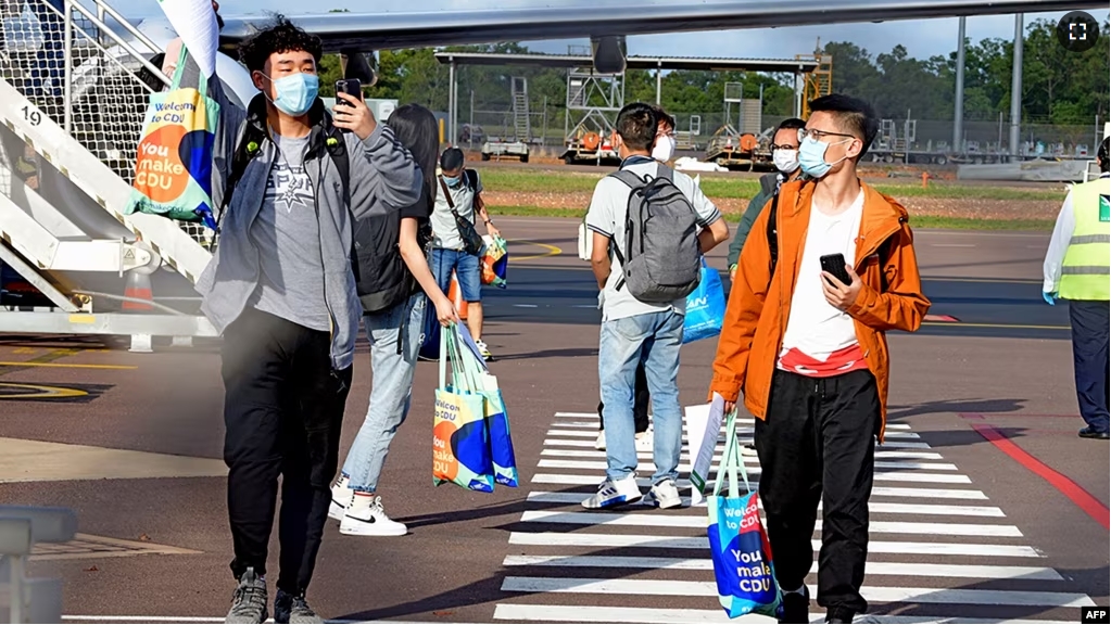 FILE - This handout picture taken on November 30, 2020 and released by Charles Darwin University shows foreign students disembarking from an international flight at Darwin Airport in Darwin. (Photo by JULES / Charles Darwin University / AFP)